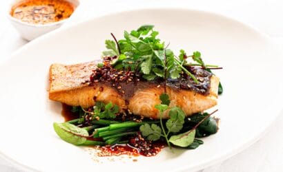 A beautifully plated dish featuring fresh South Australian Kingfish, garnished with herbs and a citrus dressing, recommended by Europa Travel Hub.