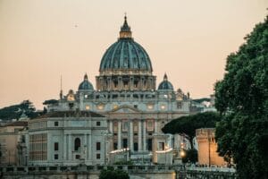 St. Peter's Basilica with a warm sunset backdrop in Vatican City, by Europa Travel Hub.