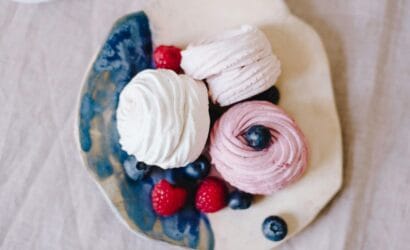 "Delicious pavlova dessert topped with fresh fruits like kiwi, strawberries, and passionfruit, a sweet Aussie treat recommended by Europa Travel Hub."