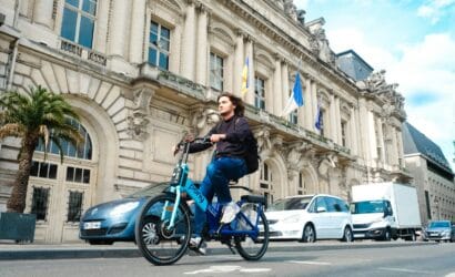 a man riding a blue bike down a street